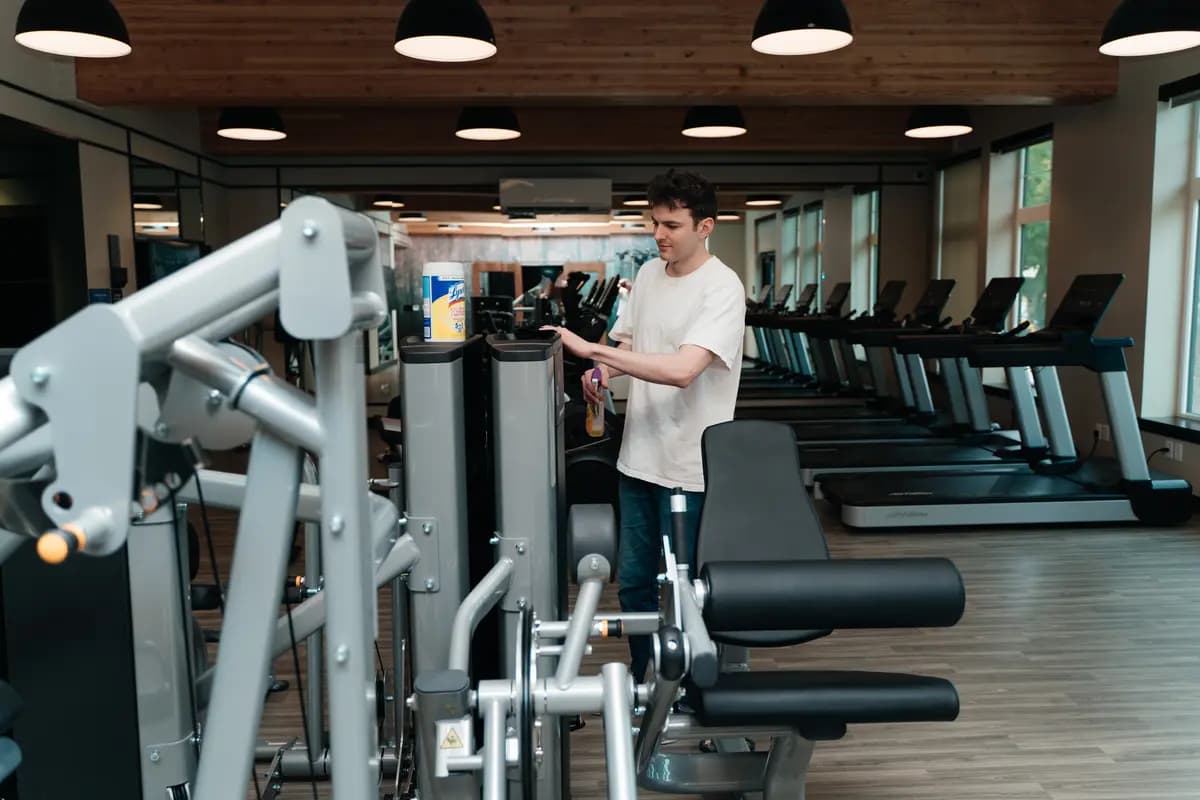 Wiping down cardio and strength equipment in a gym
