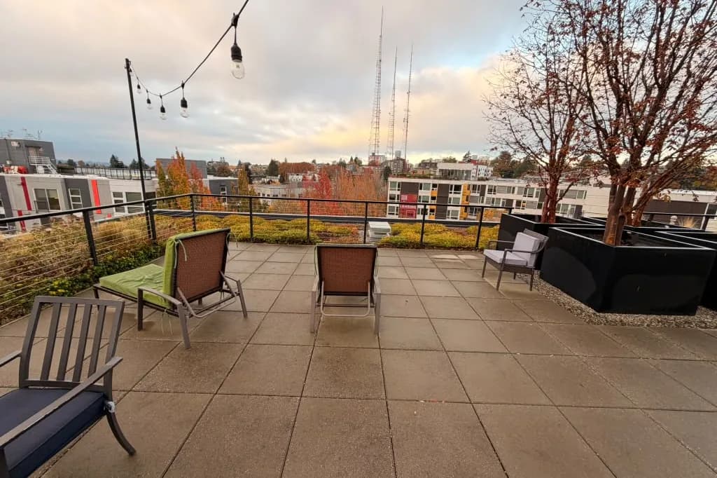 Rooftop terrace with lounge chairs and string lights at Avant Apartments, Seattle