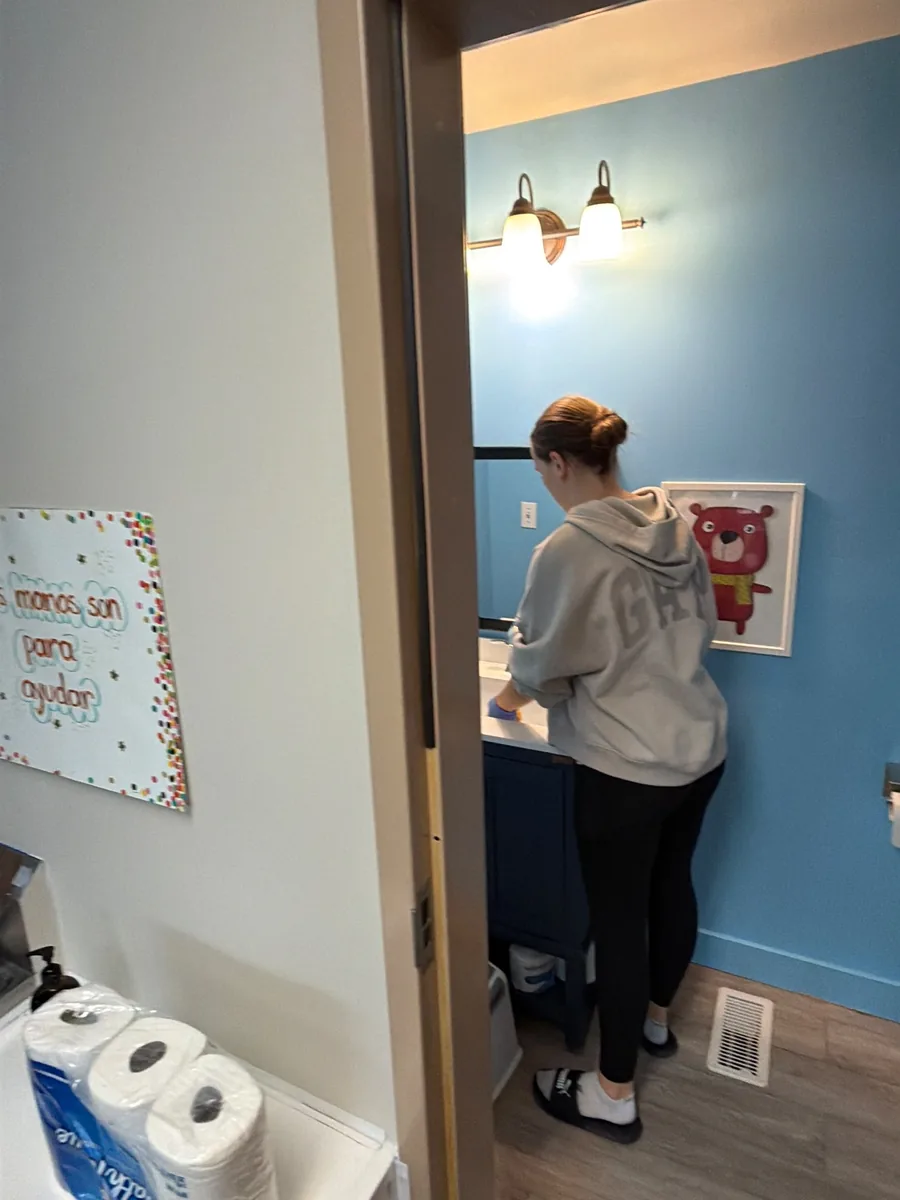 Crew member wiping down a classroom sink at a Kirkland childcare school