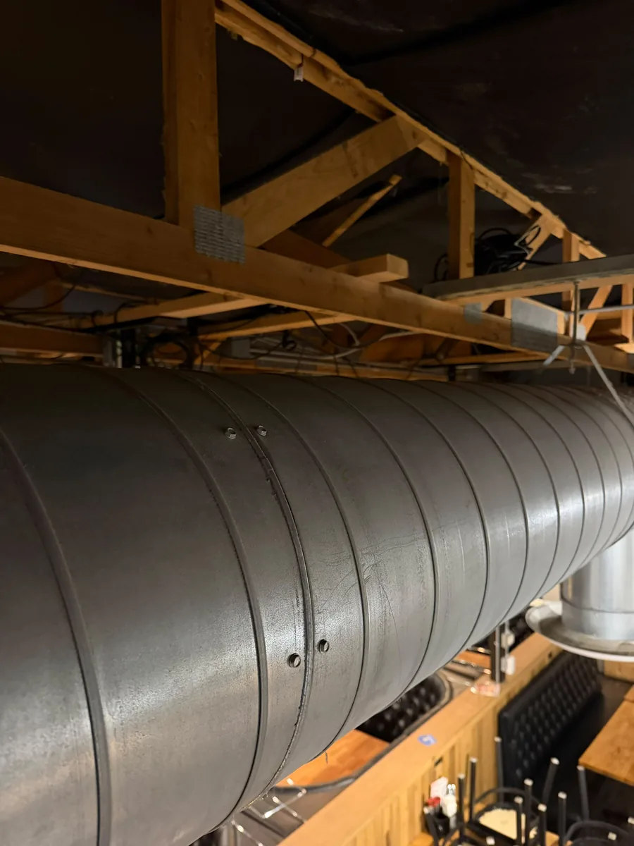 Spiral ductwork under the wood ceiling trusses at The Pizza Coop & Ale House